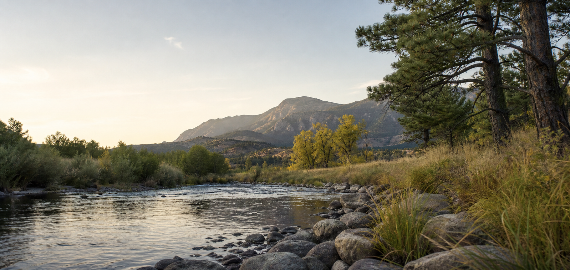 A quiet Colorado creek below foothills at morning light